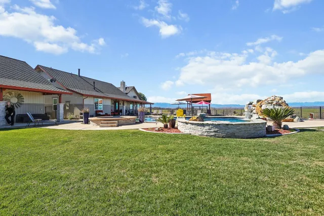 a view of a house with swimming pool and sitting area