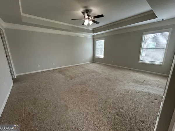 a view of a room with a ceiling fan and window