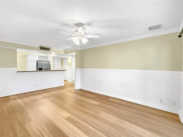 a view of a kitchen with wooden floor and ceiling fan