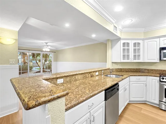 a kitchen with stainless steel appliances granite countertop a refrigerator and a sink