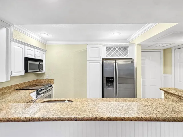 a kitchen with granite countertop stainless steel appliances granite countertop a sink and a granite counter tops