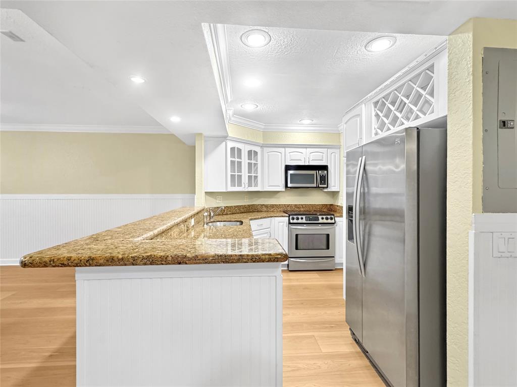1515 East Broward Boulevard, Unit 107 Fort Lauderdale, FL 33301 - Photo 9 of 36 Stylish galley kitchen features modern cabinetry, granite counters, and built-in wine rack.