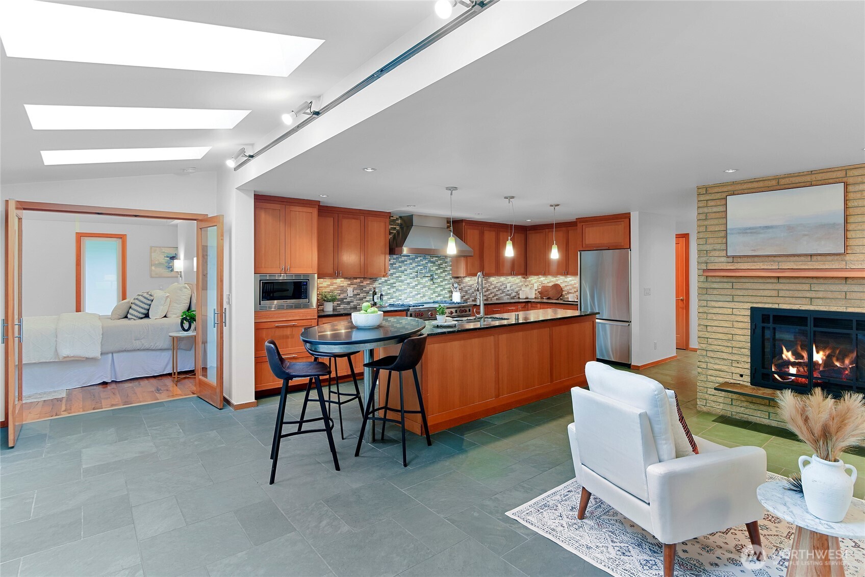 6133 Lariat Loop Bainbridge Island, WA 98110 - Photo 12 of 40 a living room with furniture a fireplace and kitchen view