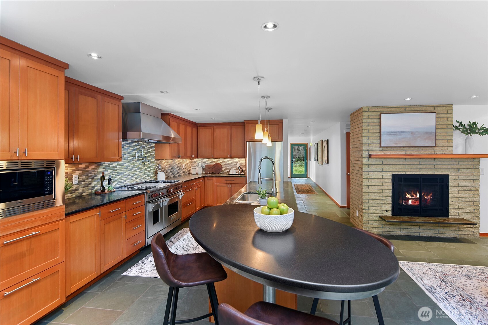 6133 Lariat Loop Bainbridge Island, WA 98110 - Photo 16 of 40 a kitchen with a dining table chairs and a fireplace