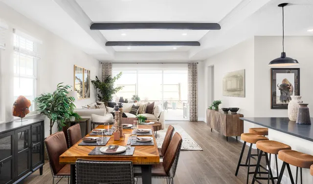 a dining room with stainless steel appliances kitchen island a table and chairs