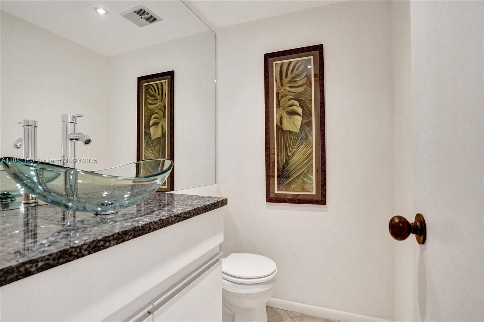 501 North Riverside Drive, Unit PH2 Pompano Beach, FL 33062 - Photo 32 of 80 a bathroom with a granite countertop sink and a toilet