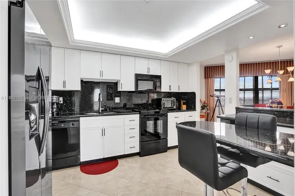 a kitchen with kitchen island granite countertop a sink and white appliances