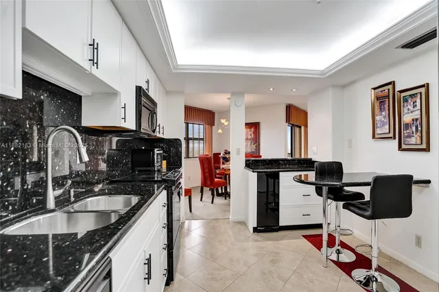 a kitchen with stainless steel appliances kitchen island granite countertop a stove a refrigerator and a sink