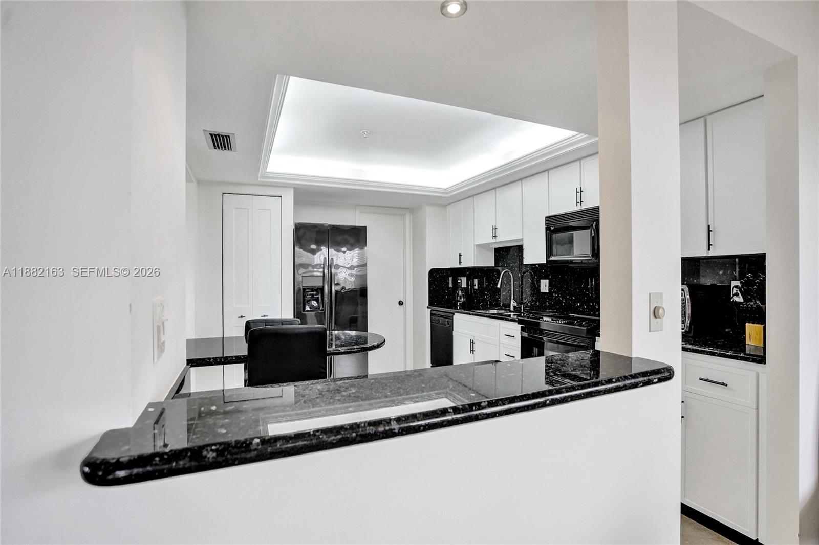 501 North Riverside Drive, Unit PH2 Pompano Beach, FL 33062 - Photo 6 of 83 a kitchen with kitchen island granite countertop a sink and white appliances