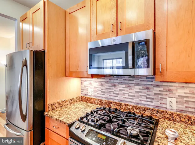 a kitchen with stainless steel appliances granite countertop a refrigerator and a sink