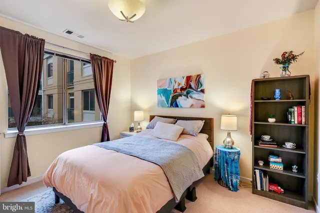 a bedroom with a bed a book shelf and a window