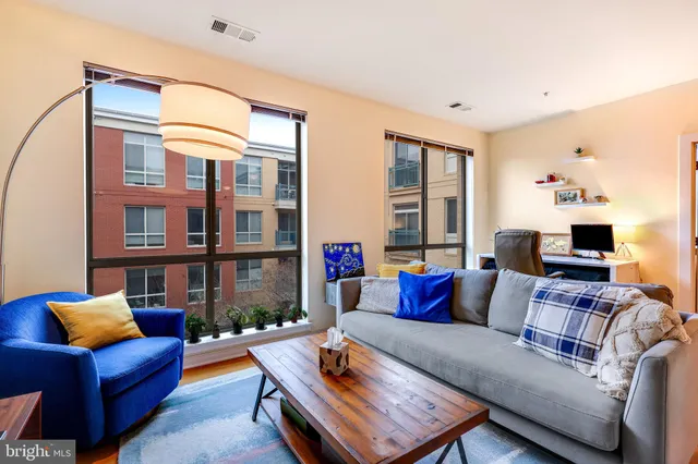 a living room with furniture fireplace and a large window
