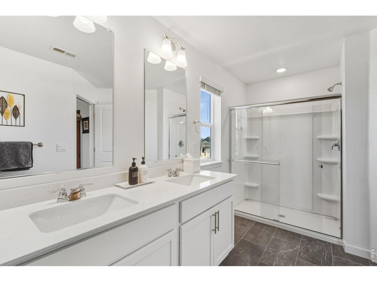 438 Bluebird Road Johnstown, CO 80534 - Photo 23 of 33 Ensuite with white double vanity, walk-in shower, and adjoining walk-in closet.