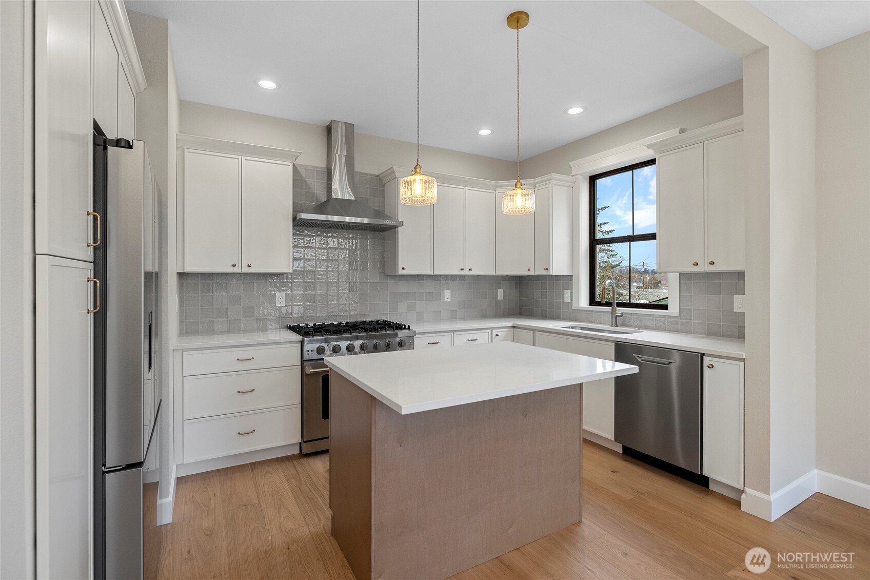 1211 King Street Anacortes, WA 98221 - Photo 14 of 40 a kitchen with stainless steel appliances granite countertop a sink a stove a refrigerator and island with wooden floor