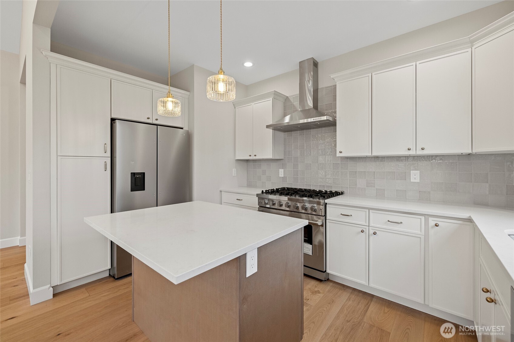 1211 King Street Anacortes, WA 98221 - Photo 16 of 40 a kitchen with stainless steel appliances a stove a refrigerator a sink and white cabinets