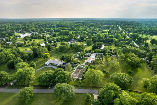 an aerial view of residential houses with outdoor space and trees