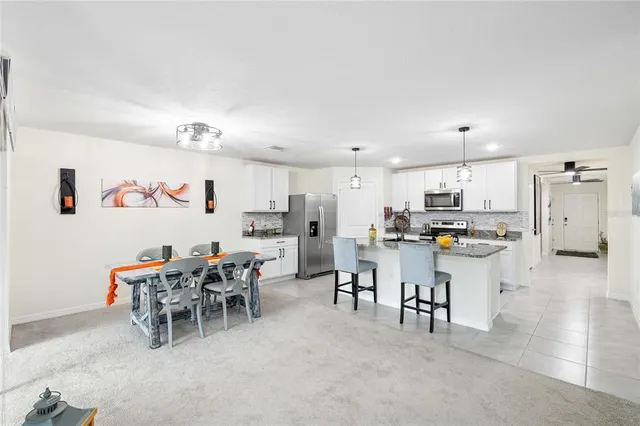 a living room with lots of furniture and kitchen view