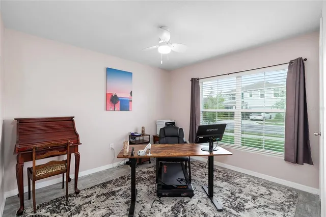 a view of a workspace with furniture and a window