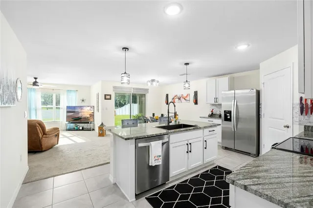 a kitchen with stainless steel appliances granite countertop a sink and a refrigerator