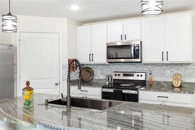 a kitchen with stainless steel appliances granite countertop a stove and a microwave