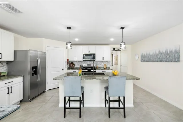 a kitchen with stainless steel appliances kitchen island a refrigerator and a stove top oven