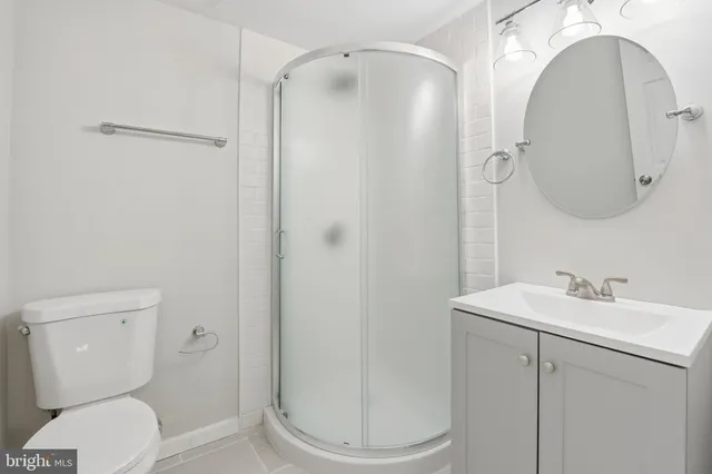 a bathroom with a toilet sink vanity and mirror