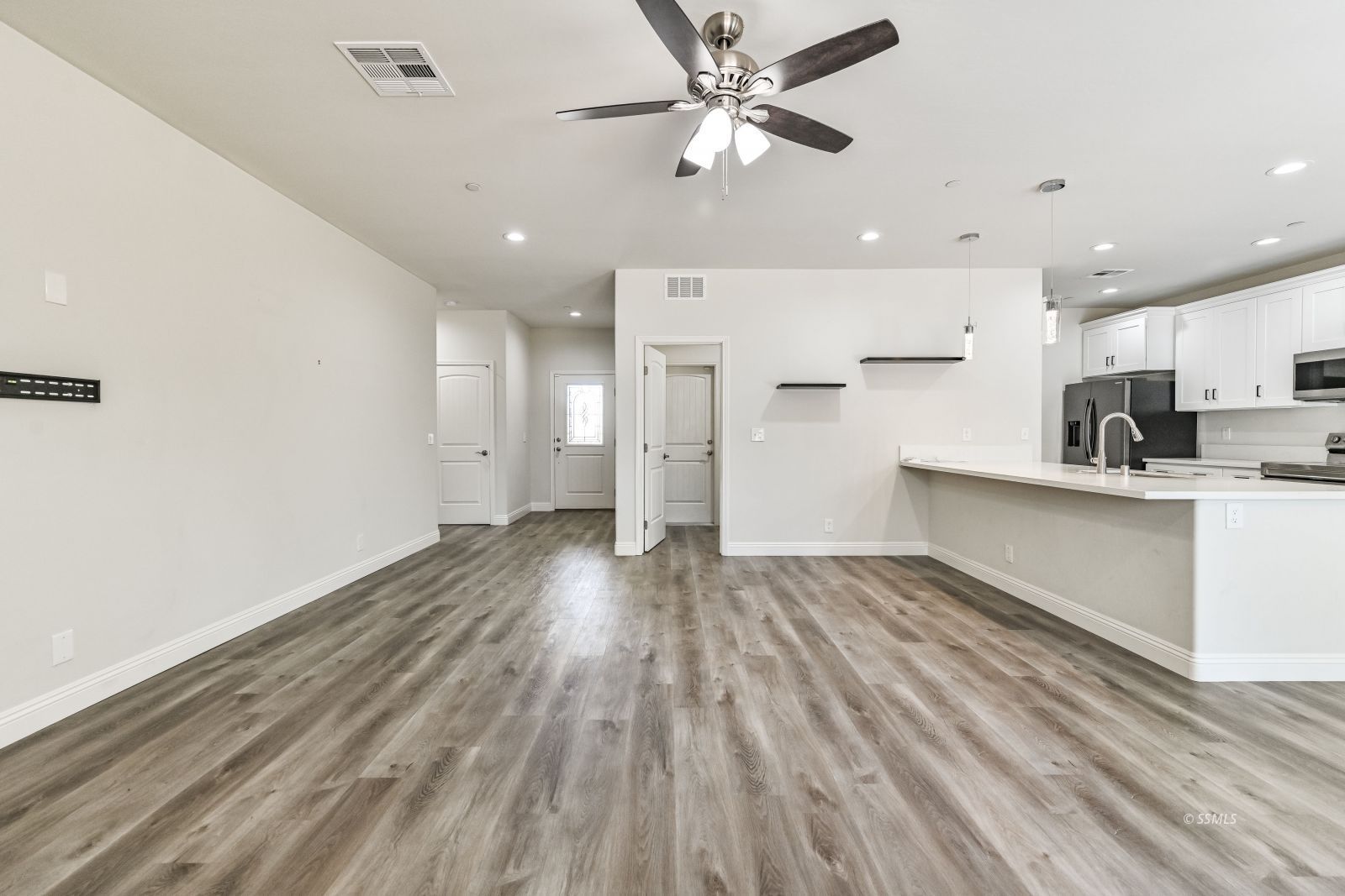 1031 West Church Avenue Ridgecrest, CA 93555 - Photo 15 of 49 a view of empty room with wooden floor and ceiling fan