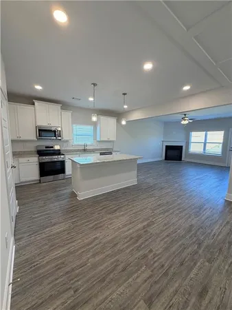 a view of kitchen with granite countertop stainless steel appliances refrigerator oven stove microwave and cabinets