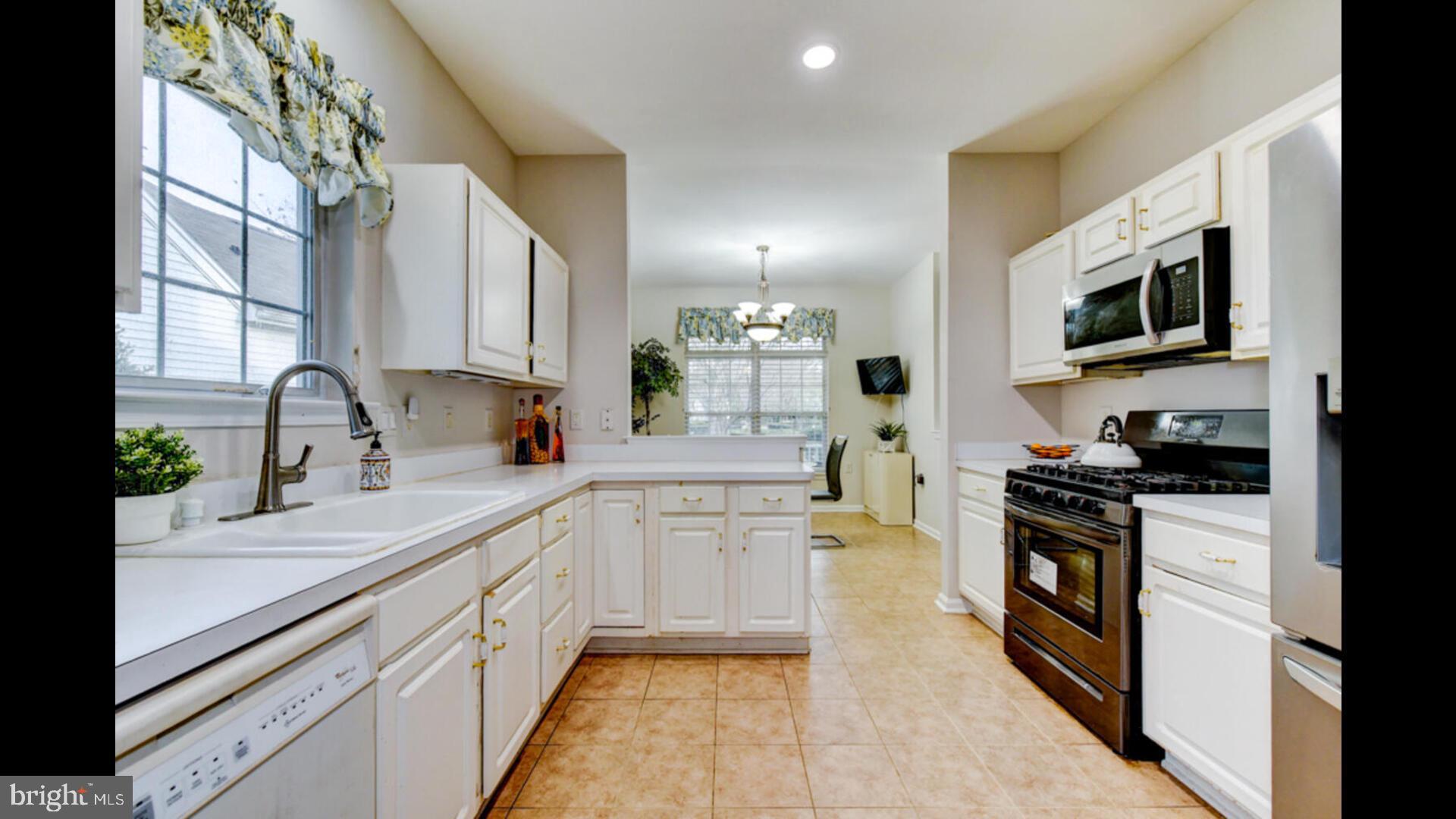 25 Cardinal Flower Lane Princeton Junction, NJ 08550 - Photo 19 of 54 a kitchen with stainless steel appliances granite countertop white cabinets a sink dishwasher a stove and a refrigerator with wooden floor