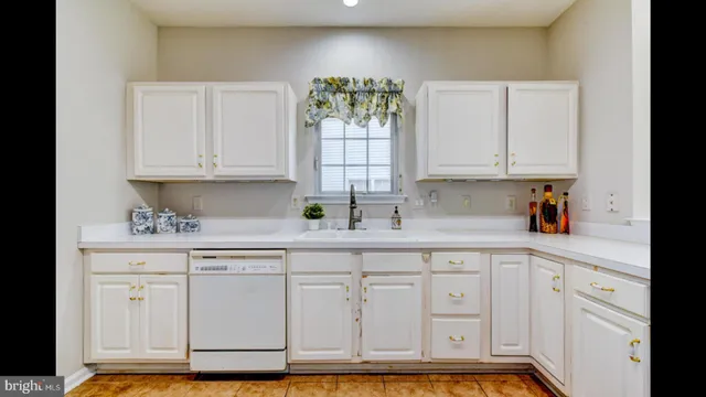 a kitchen with granite countertop white cabinets stainless steel appliances and a counter space