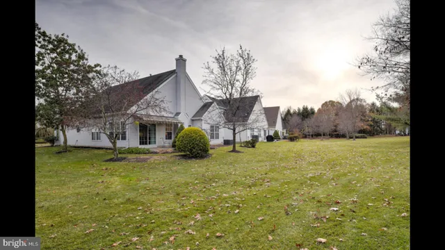a view of a house with a yard and palm trees