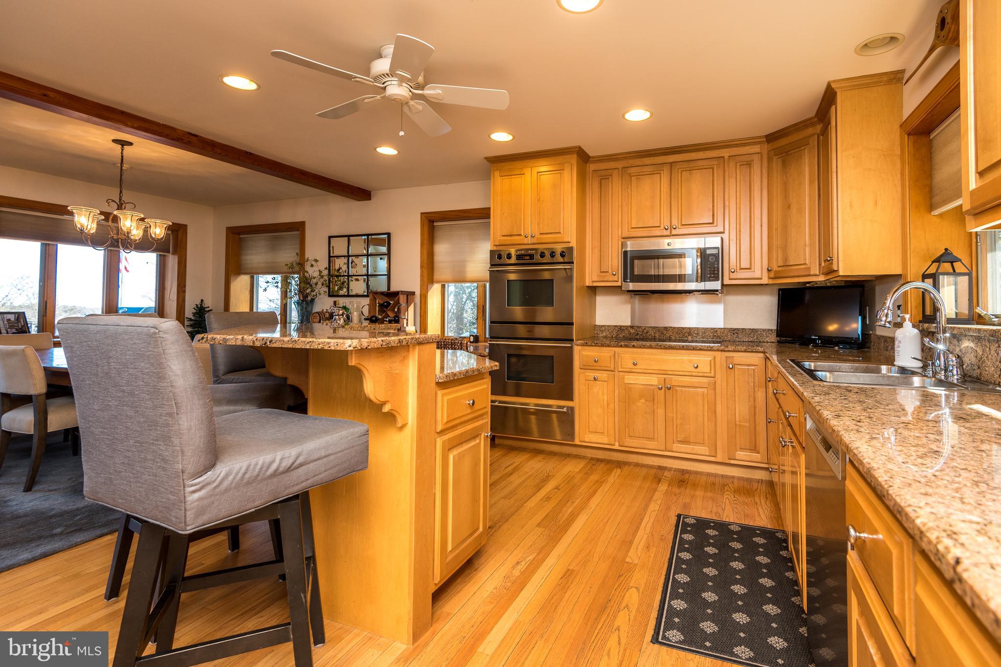 791 Temple Road Pottstown, PA 19465 - Photo 21 of 82 a kitchen with stainless steel appliances granite countertop a refrigerator a sink dishwasher a stove and a dining table with wooden floor