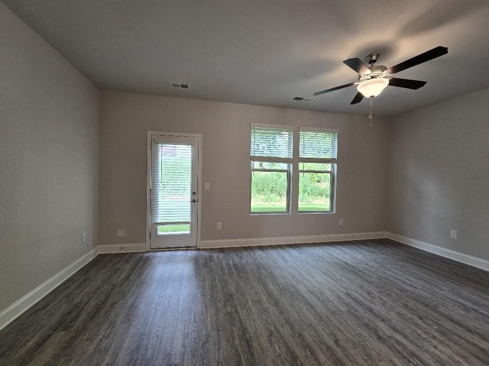 6206 Ripple Way, Unit 89 Atlanta, GA 30349 - Photo 14 of 26 an empty room with wooden floor chandelier fan and windows