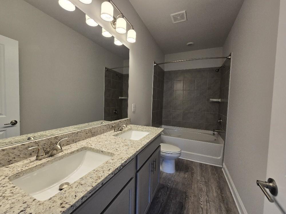 6206 Ripple Way, Unit 89 Atlanta, GA 30349 - Photo 22 of 26 a bathroom with a granite countertop sink a toilet and bathtub