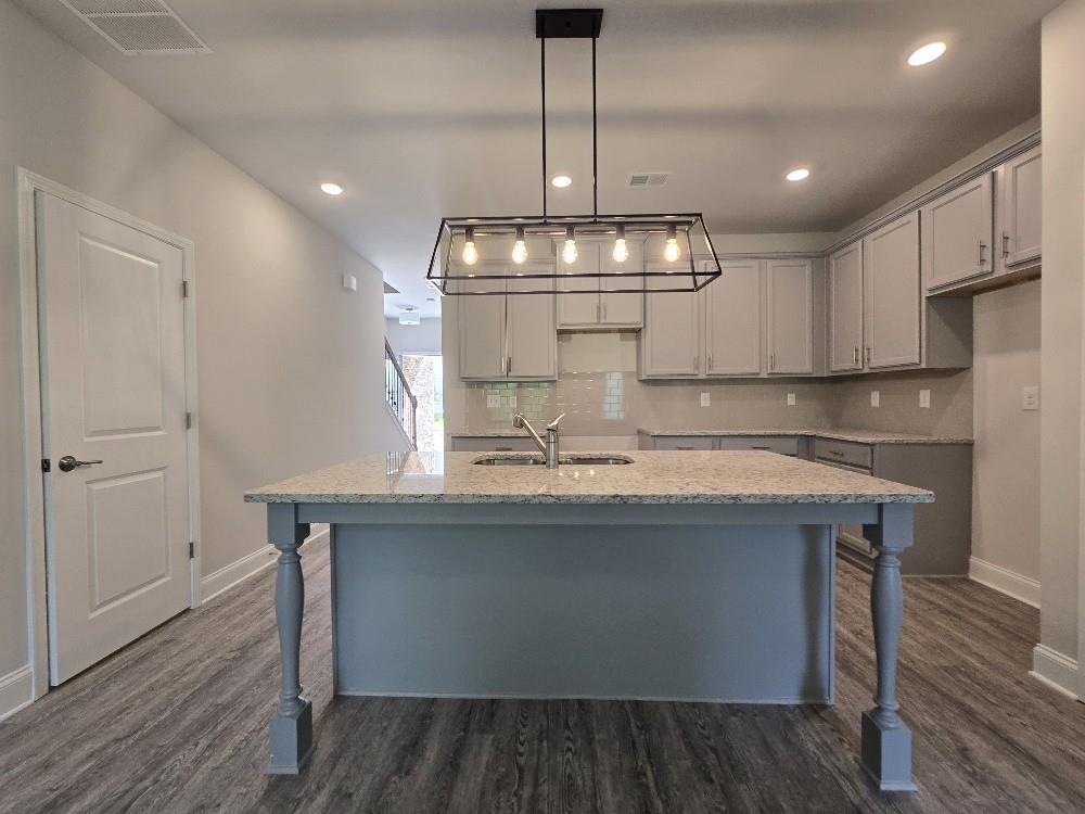 6206 Ripple Way, Unit 89 Atlanta, GA 30349 - Photo 3 of 26 a kitchen with kitchen island stainless steel appliances a stove refrigerator and wooden floor