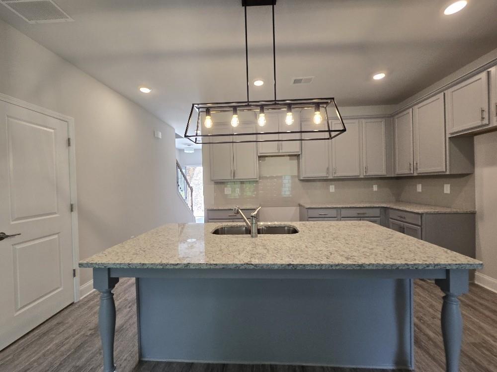 6206 Ripple Way, Unit 89 Atlanta, GA 30349 - Photo 5 of 26 a kitchen with a table a sink and cabinets