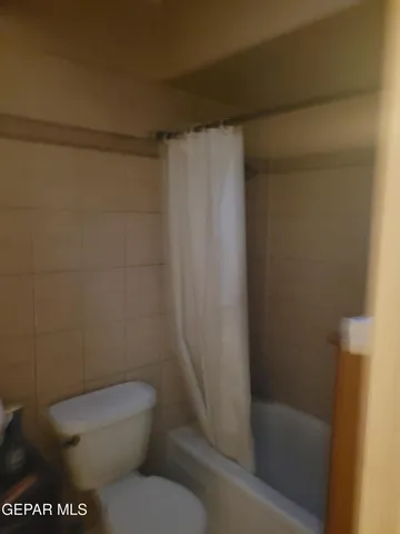 a white toilet sitting next to a shower