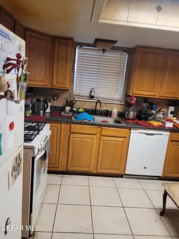 a kitchen with a stove a sink dishwasher and a refrigerator