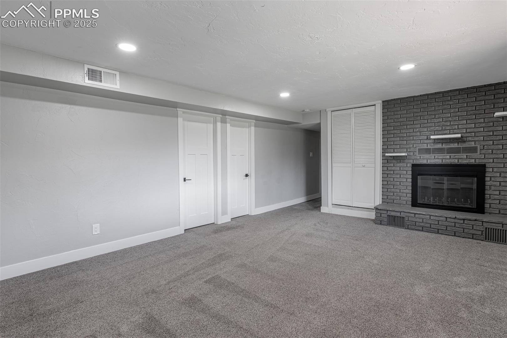 721 Forest View Road Monument, CO 80132 - Photo 41 of 47 Basement Living Room with bedroom and bathroom doors. Laundry down the hall