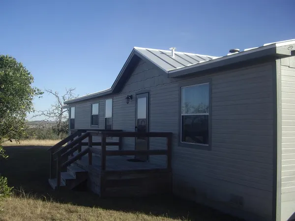 a view of house with backyard and seating space