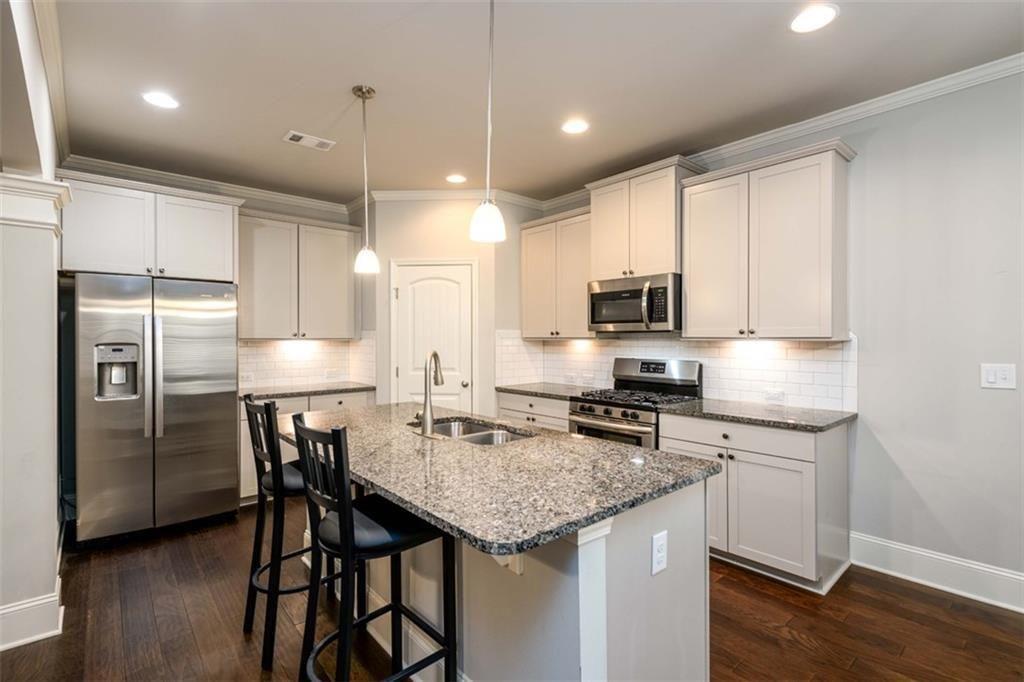 6622 Trailblazer Road Flowery Branch, GA 30542 - Photo 12 of 51 a kitchen with a stove a refrigerator and a sink