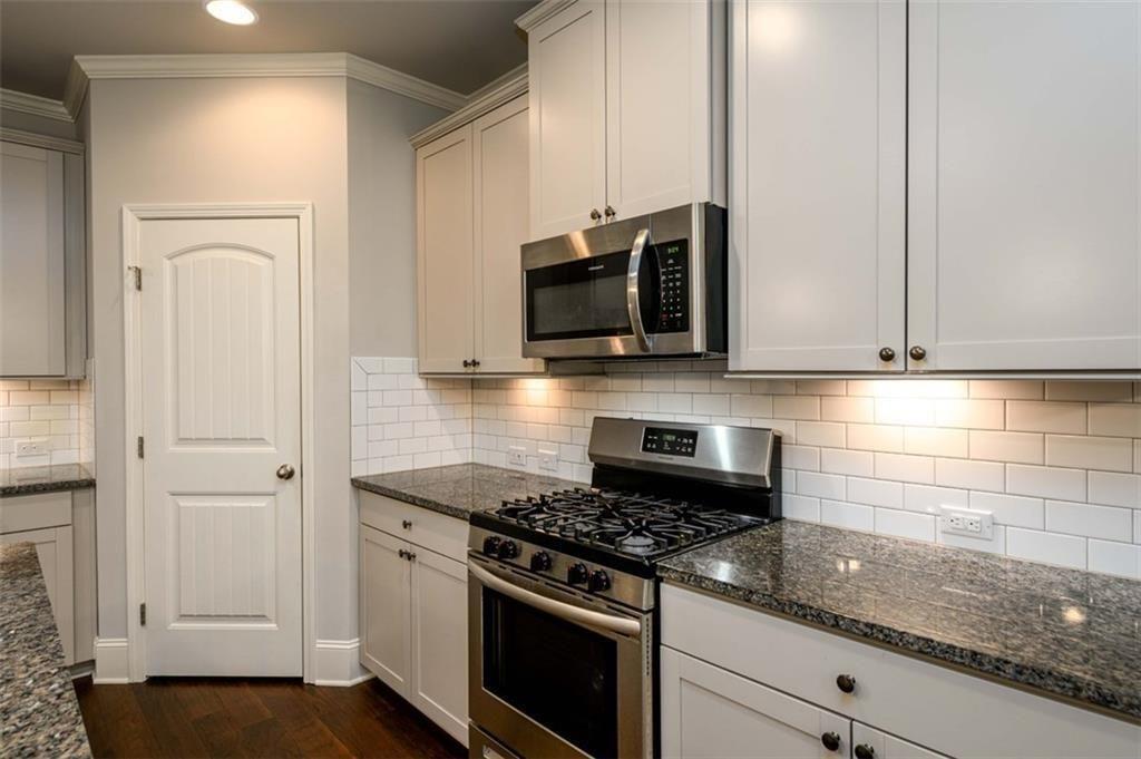 6622 Trailblazer Road Flowery Branch, GA 30542 - Photo 13 of 51 a kitchen with stainless steel appliances granite countertop white cabinets and a stove