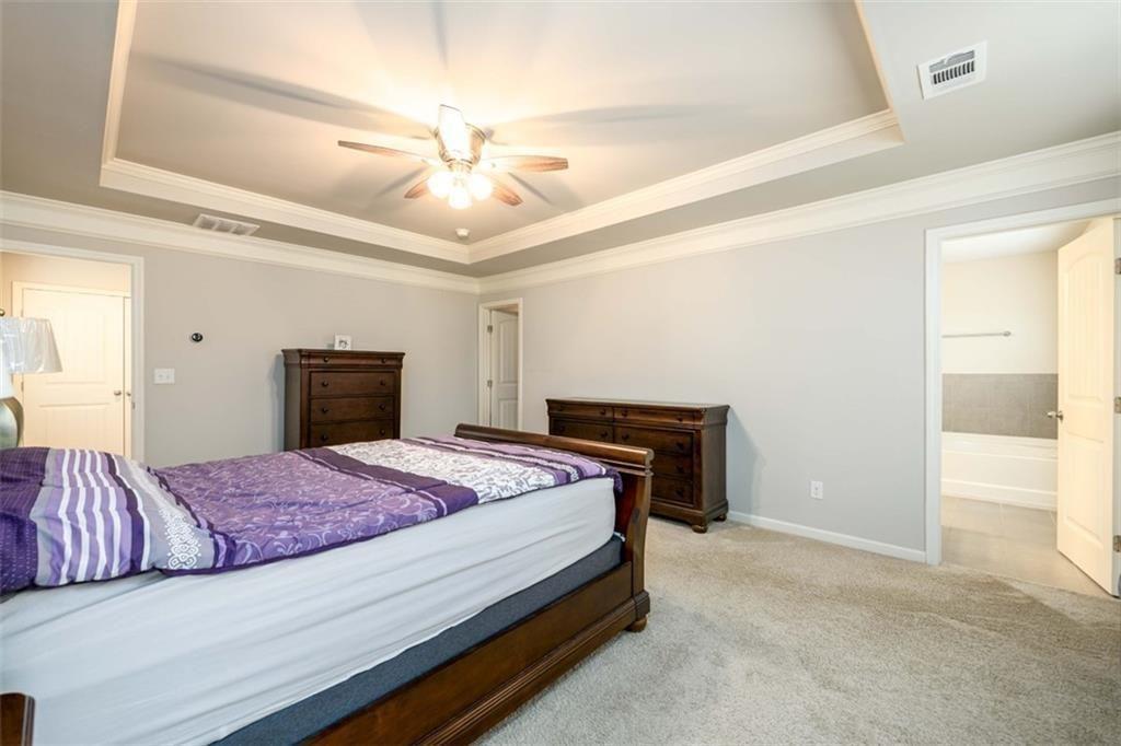 6622 Trailblazer Road Flowery Branch, GA 30542 - Photo 22 of 51 a bedroom with a bed and a chandelier