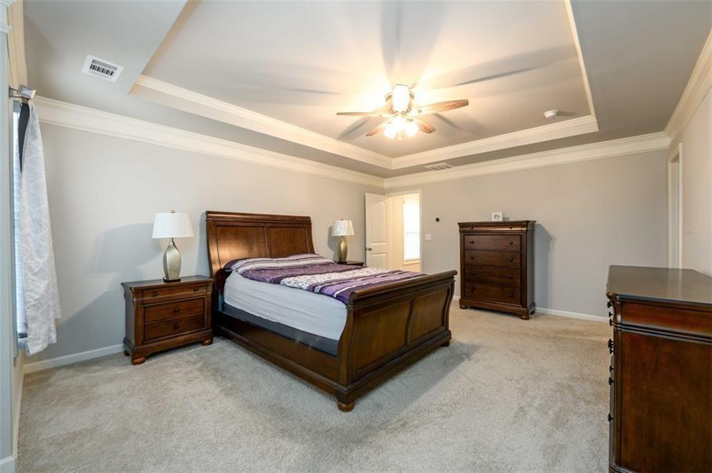 6622 Trailblazer Road Flowery Branch, GA 30542 - Photo 23 of 51 a bedroom with a bed and a chandelier