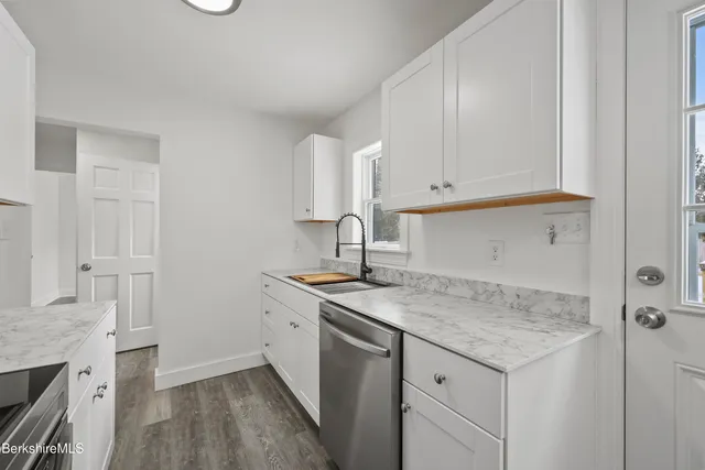 a kitchen with a sink cabinets and wooden floor