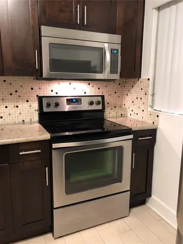 a kitchen with microwave cabinets and stove top oven