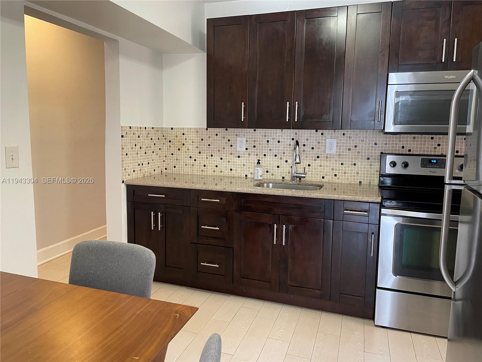 219 Southwest 9th Avenue, Unit 2 Miami, FL 33130 - Photo 7 of 28 a kitchen with granite countertop a stove and a refrigerator