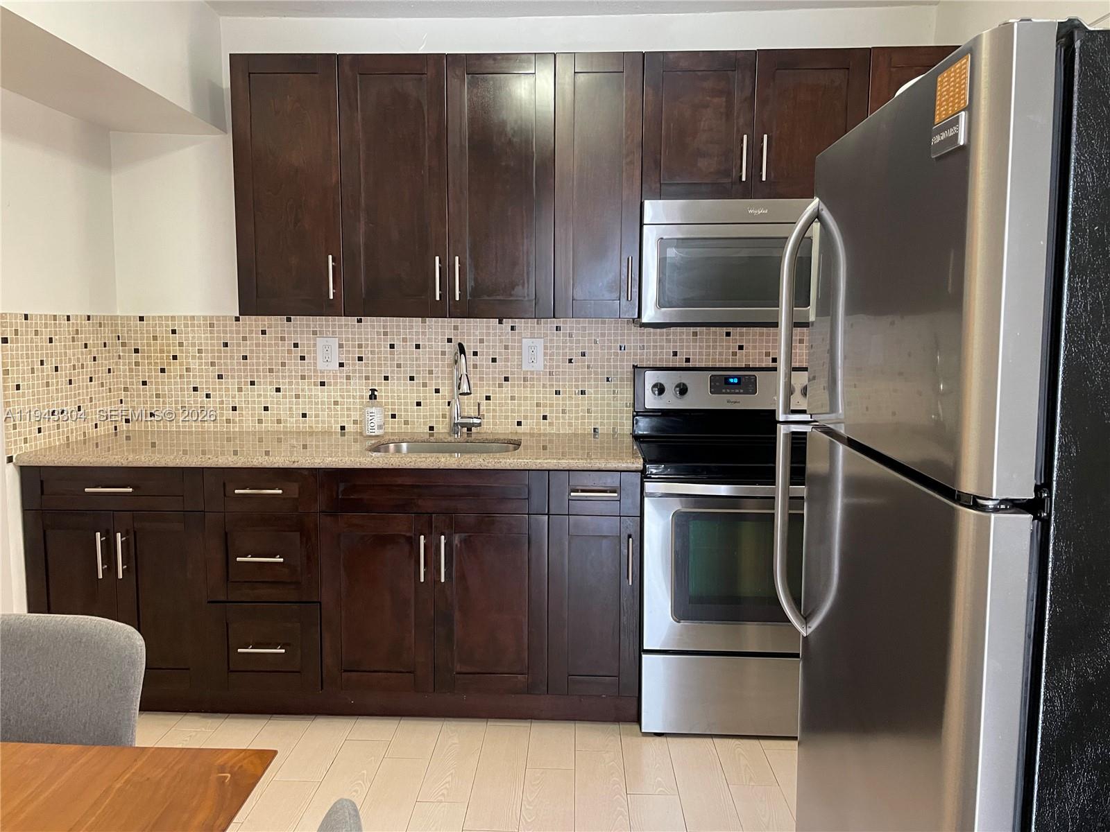 219 Southwest 9th Avenue, Unit 2 Miami, FL 33130 - Photo 9 of 28 a kitchen with stainless steel appliances granite countertop a refrigerator and a sink