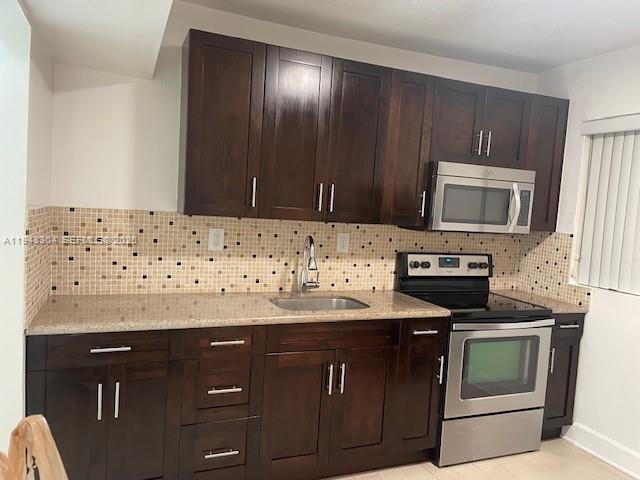 219 Southwest 9th Avenue, Unit 2 Miami, FL 33130 - Photo 10 of 28 a kitchen with granite countertop wooden cabinets and stainless steel appliances