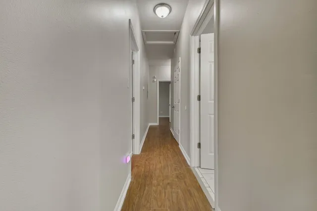 a view of a hallway with wooden floor